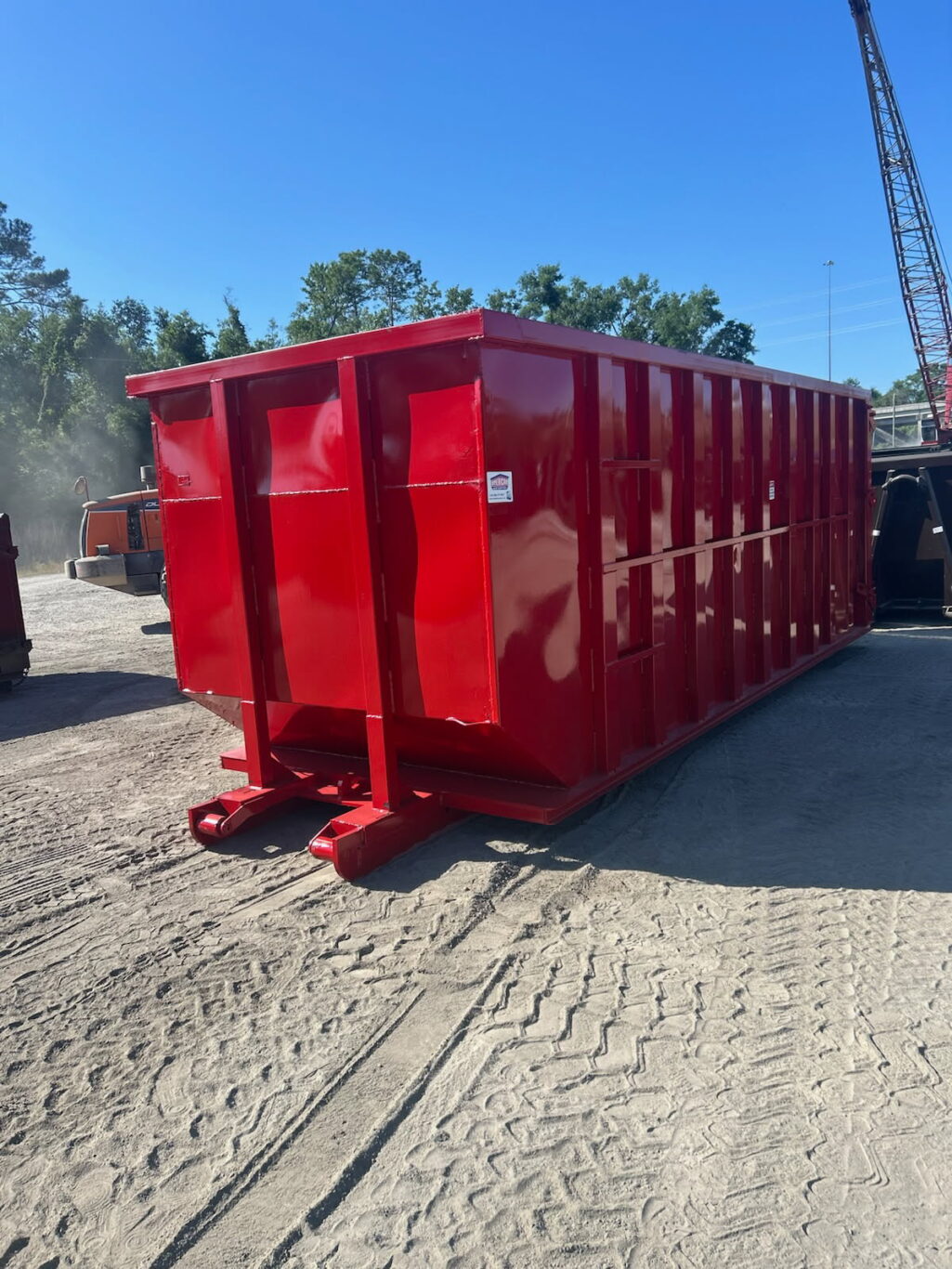 "Large red 40-yard roll-off dumpster on a commercial job site"