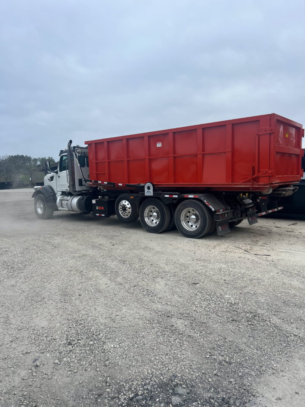 Countrywide Disposal roll-off truck unloading a 30-yard dumpster for nationwide rental service.